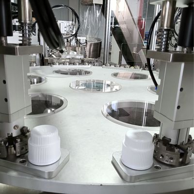 Automated assembly machine for laundry lids with turntable operation and elevator type loading.